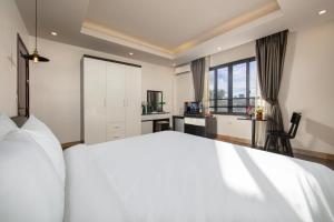 a bedroom with a large white bed and a desk at Hotel Del Couple Sapa in Sapa