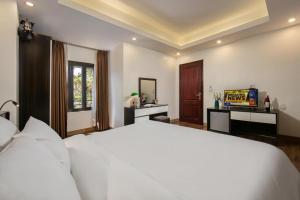 a bedroom with a large white bed and a television at Hotel Del Couple Sapa in Sapa