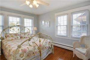 a bedroom with a bed and a chair and windows at The Cape May Diamond in Cape May +31 photos