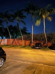 a car parked on the side of a street with palm trees at Suite Kimia - Chic T2, Rue Des Jardins, Cocody, Vallon, Abidjan in Abidjan