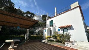 a white building with a lighthouse in the background at Villa Lyla in Capri