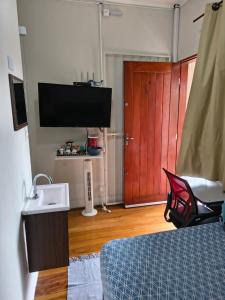 a bedroom with a bed and a sink and a tv at Pousada Seu Jorge in Campinas