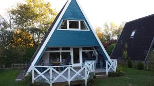 a blue and white triangular house with a porch at Strandpirat in Damp