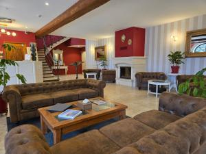 a living room with couches and a fireplace at CÉRÈS - Boutique-Hôtel & Spa - Élégance en Terre d'Uzès in Saint-Quentin-la-Poterie