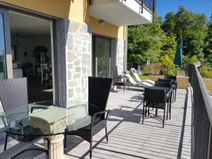 a patio with chairs and a glass table at Stella Maggiore in Verbania