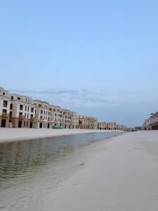 an empty beach with buildings in the distance at Na homes coffee in Binh Hai