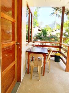 a wooden table and chairs on a porch with a door at Gregorio's Inn in San Vicente +50 photos