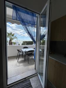 a sliding glass door leading to a patio with a table at Villetta sullo Scoglio in Gela