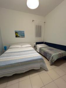 a bedroom with two beds and a light fixture at Villetta sullo Scoglio in Gela