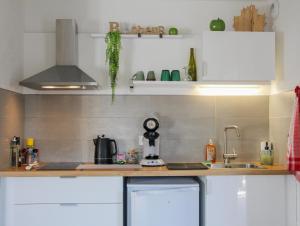a kitchen with white cabinets and a sink at L'Obernai in Obernai