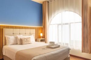 a bedroom with a large bed with a large window at Hotel Anddari in Arequipa