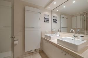 a bathroom with two sinks and two mirrors at Appartement Lycka in Keitum +28 photos