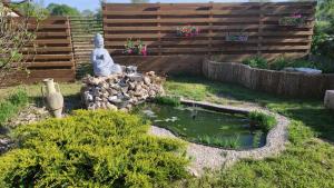 a small pond with a statue in a garden at La Maison d'eglantine in Marnaves