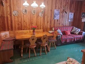 a room with a wooden table and chairs and a couch at Terminillo Lo chalet in Terminillo