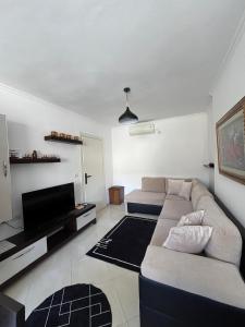 a living room with a couch and a flat screen tv at Apartament Qetesia in Çorovodë