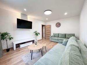 a living room with a couch and a table at Green Oasis Apartment in Myslava