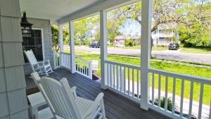 a porch with white chairs and a view of a street at 1036 Maryland Ave in Cape May
