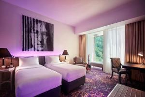 a hotel room with two beds with purple lighting at Hard Rock Hotel Penang in Batu Ferringhi