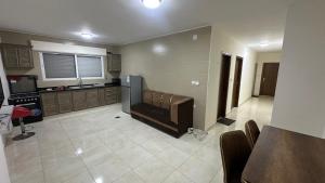 a kitchen with a couch in the middle of a room at Local apartment in Irbid