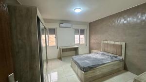 a bedroom with a bed and a desk in it at Local apartment in Irbid