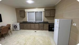 a kitchen with a white refrigerator and a table with chairs at Local apartment in Irbid +10 photos