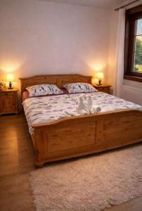 a bedroom with a wooden bed with two pillows at Kuća za odmor Petra in Erdut