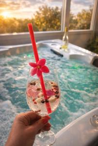 a person holding a drink with a flower in a bath tub at Kuća za odmor Petra in Erdut
