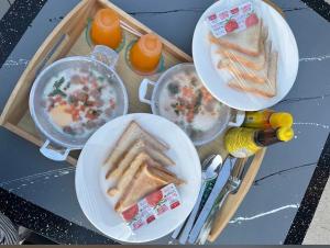 three plates of food on a table with food at Baan Noah บ้านโนอาห์ in Lop Buri