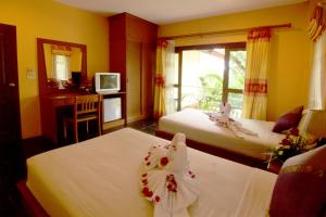 a hotel room with two beds with flowers on them at Aonang Lake Side in Ao Nang Beach