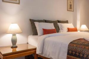 a bedroom with a bed with two lamps on a table at Sirinary Villa - Natai Phangnga in Ban Na Tai +2 photos