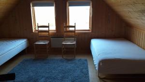 a room with two beds and two chairs and two windows at Mid-Sel mountain view lodge in Hella