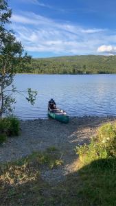 a small boat sitting on the shore of a lake at Cabin in Tydal, enjoy! in Tydal