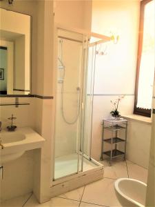uma casa de banho com uma cabina de duche em vidro e um lavatório. em Peacefull in Duomo em Florença