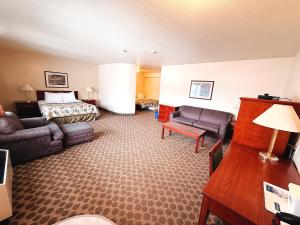 a hotel room with a bed and a couch at Travelodge by Wyndham Drumheller AB in Drumheller