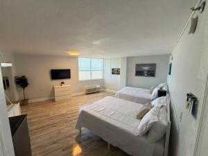 a bedroom with two beds and a flat screen tv at Beach Front Resort with Ocean View in Daytona Beach +16 photos