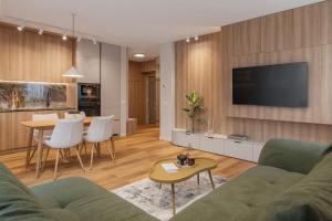 a living room with a couch and a tv and a table at Honey Oak Residence in Oradea