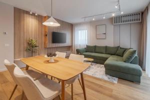 a living room with a table and a green couch at Honey Oak Residence in Oradea +15 photos