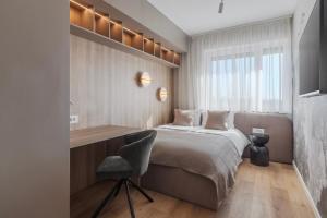 a bedroom with a bed and a chair and a window at Honey Oak Residence in Oradea