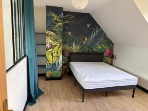 a bed in a room with a painting on the wall at Iroise in Combrit +6 photos