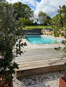 a wooden bridge over a swimming pool in a garden at Iroise in Combrit