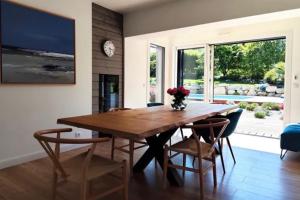 a dining room with a wooden table and chairs at Iroise in Combrit