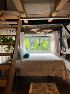 a bedroom with a bunk bed and a large window at Casa Sabia com charme rústico e belos jardins in Benedito Novo