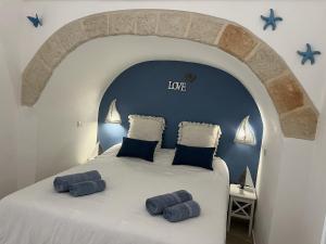 a bedroom with a large bed with blue pillows at Mamy Sweet Loft in Polignano a Mare