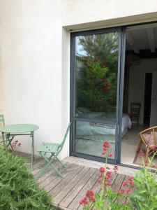 a sliding glass door on a patio with a table at Chai Léopold in Surgères