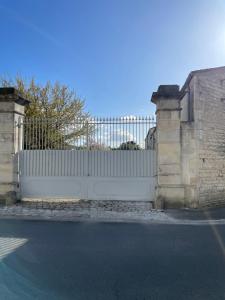 a white gate with a white fence at Chai Léopold in Surgères