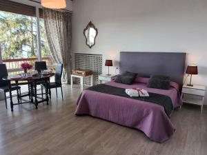 a bedroom with a purple bed and a table and chairs at Belvedere del Lago in Montefiascone