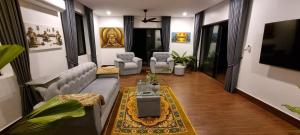 a living room with a couch and a table and chairs at Bayon Country Villa in Phumĭ Trás Treăng