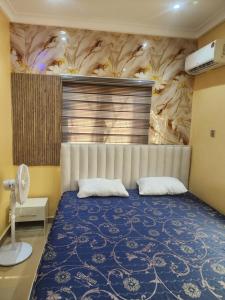 a bedroom with a large bed with a blue bedspread at The Oasis in Oko Erin