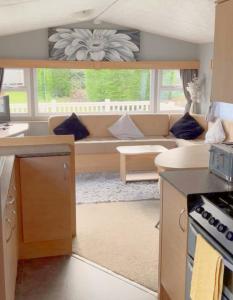 a living room with a couch and a table at 609 Sycamore Forest in Newquay +1 photo