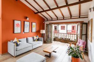 a living room with orange walls and a couch at Casa Sie in Villa de Leyva